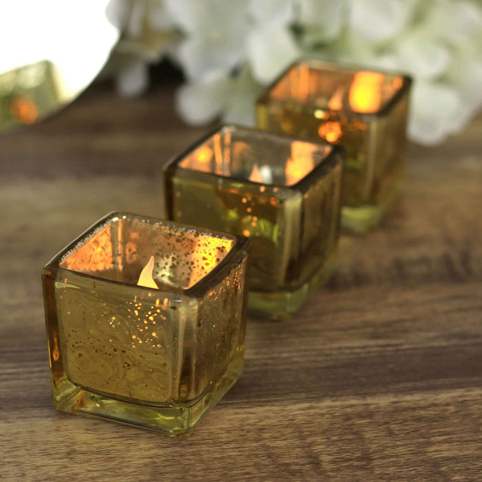 Set of three amber glass candle holders with warm flickering flames.