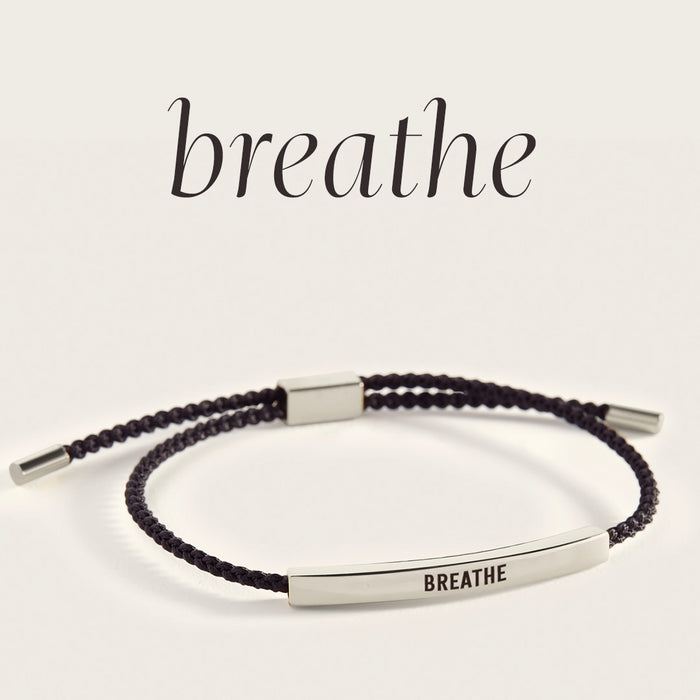 Bracelet with 'BREATHE' engraving on a light background