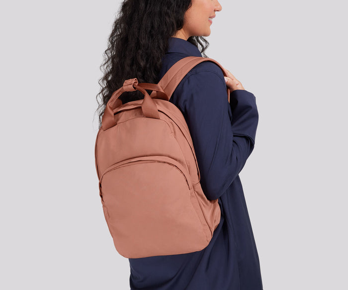 Person wearing the Featherlight Backpack on one shoulder
// 
Model is 5'7"