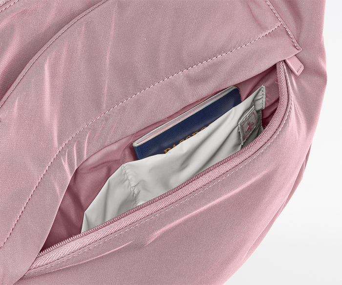 Pink bag with a compartment open, revealing a passport and money.