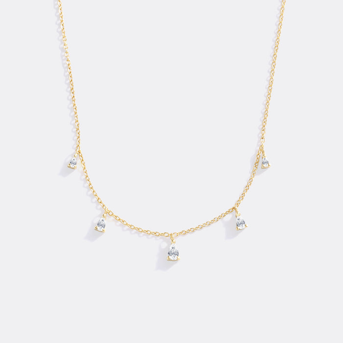 Gold necklace with small pendants on a white background