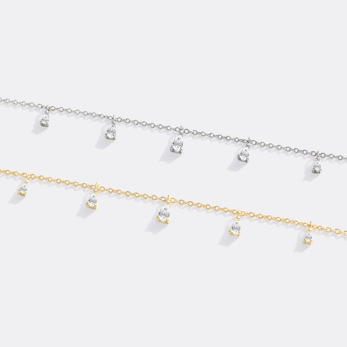 Two gold necklaces with small pendants on a white background