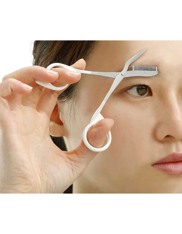 Woman using eyebrow scissors for grooming