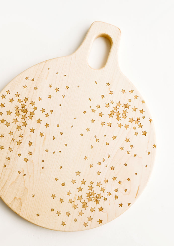 Round paddle-style cutting board in maple wood with scattered star pattern